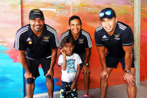 david wirrpanda troy cook and dale kickett of the wirrpanda foundation stand with young male child in front of art mural