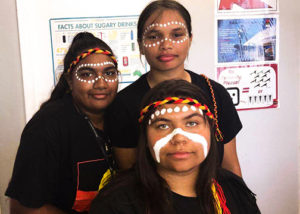 3 teenage girls in aboriginal cultural dress and face paint