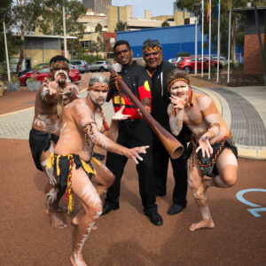 a group of men in aboriginal cultural dress in dance poses